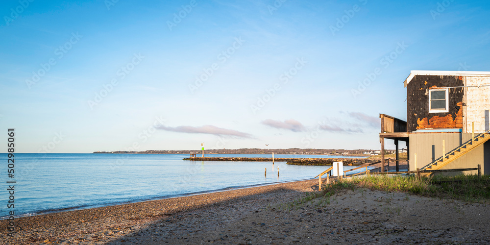 Beach seascape after the storm with a partial view of a damaged house