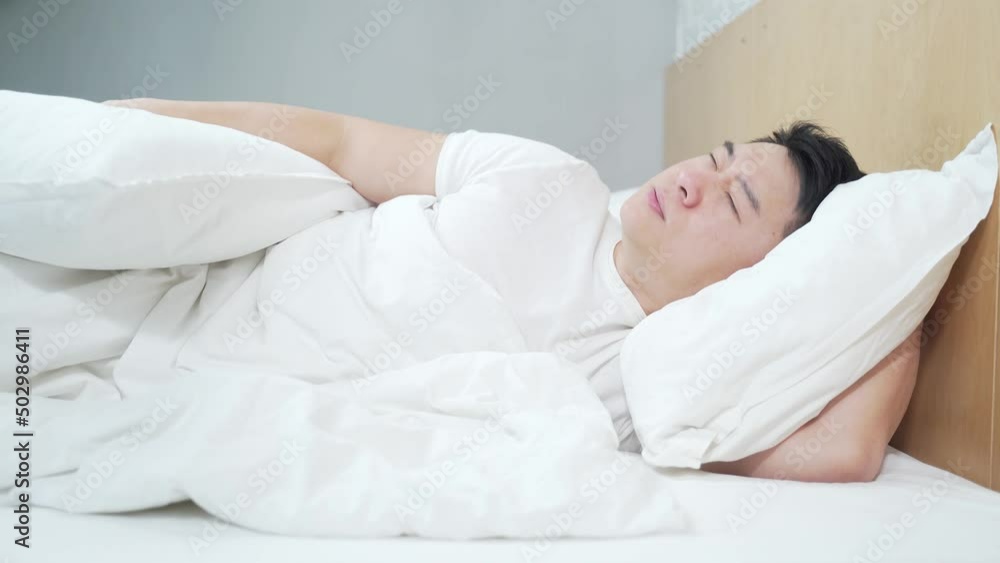 problem of sound insulation and thin walls in apartment House Asian man in Bed Tries To Rest, Irritated By Noisy Neighbors. Insomnia, Repair Work at the Neighbors. The Concept of Neighborhood problem of sound insulation and thin walls in apartment House Asian man in Bed Tries To Rest, Irritated By Noisy Neighbors. Insomnia, Repair Work at the Neighbors. The Concept of Neighborhood