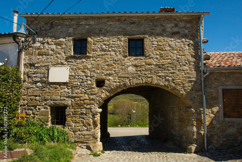 An old residential building in the historic little medieval village of Roc near Buzet in Istria, western Croatia. A town gateway runs through the building 