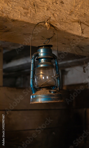 Old Rusty Blue Antique Oil Lantern Hanging in a Barn