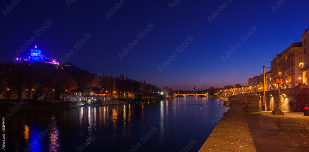 Fototapeta premium Turin, Italy. February 15, 2022. View of the Po river at night with the Church of Santa Maria del Monte dei Cappuccini on the left and Umberto I Bridge at the center.