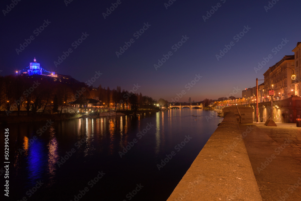 Fototapeta premium Turin, Italy. February 15, 2022. View of the Po river at night with the Church of Santa Maria del Monte dei Cappuccini on the left and Umberto I Bridge at the center.