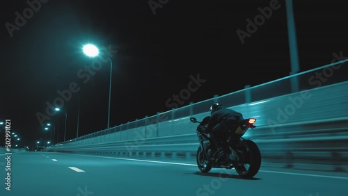 A man rides a sports motorcycle on a night track photo