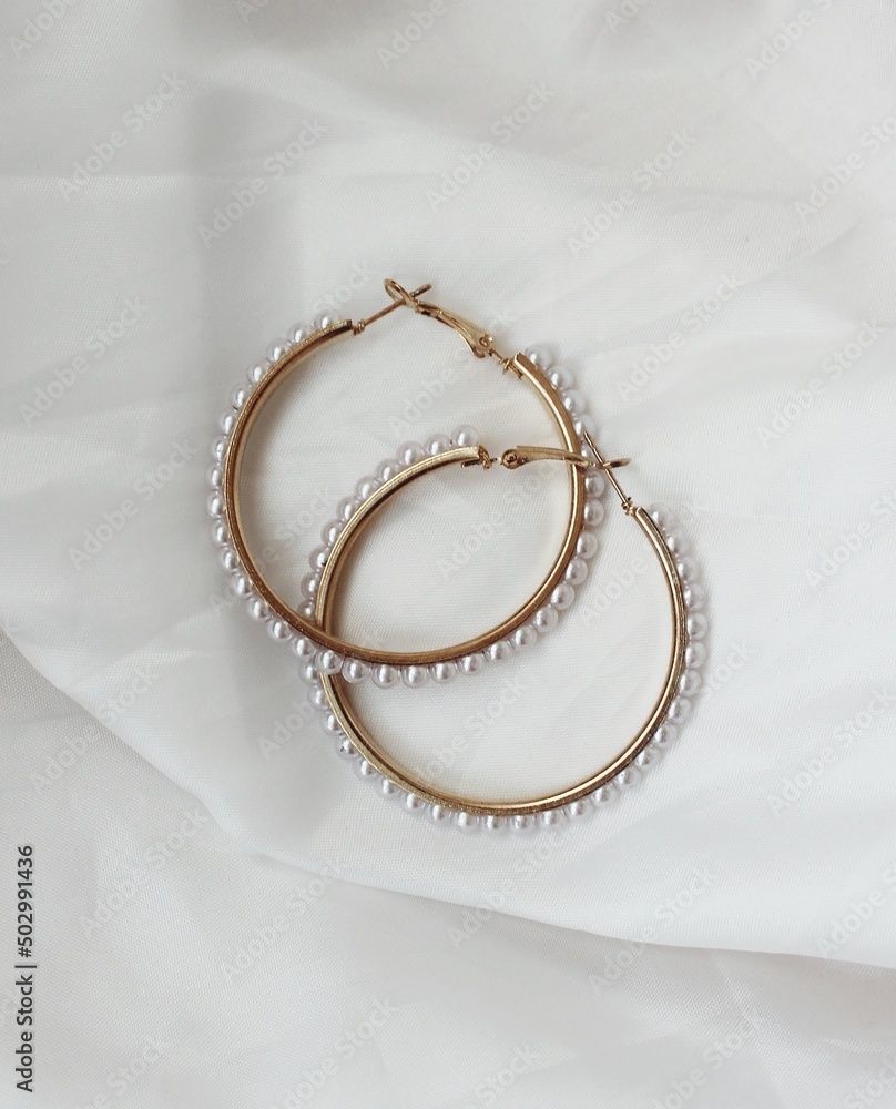 Golden rings with pearls on a light background Golden rings with pearls on a light background