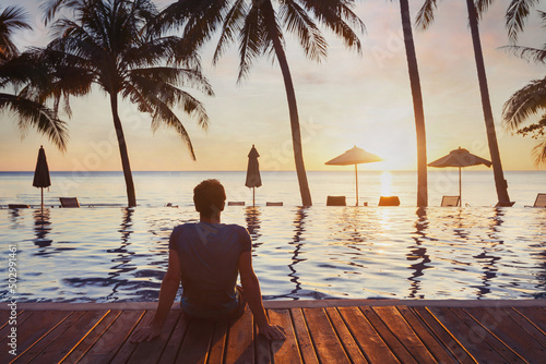 beach holidays, tourist enjoying beautiful sunset in luxury hotel near swimming pool