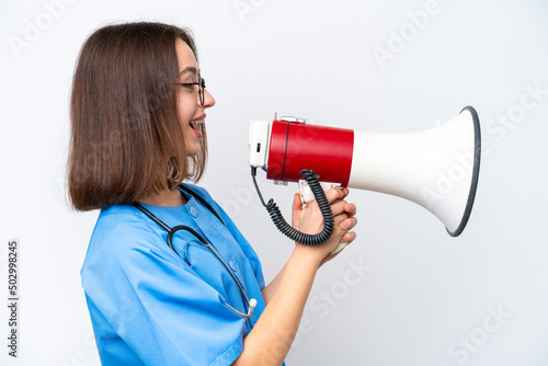 Young nurse Ukrainian woman isolated on white background shouting through a megaphone