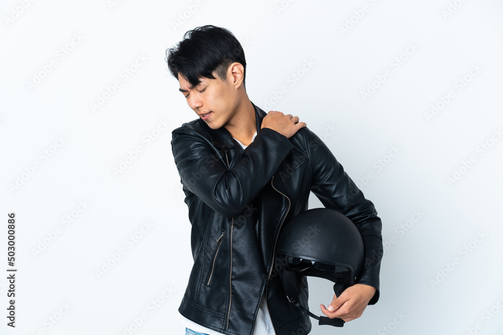 Chinese man with a motorcycle helmet isolated on white background suffering from pain in shoulder for having made an effort Chinese man with a motorcycle helmet isolated on white background suffering from pain in shoulder for having made an effort