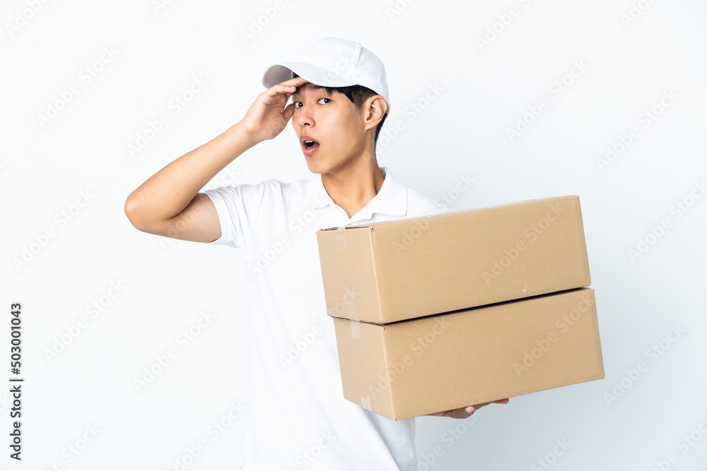 Delivery Chinese man isolated on white background doing surprise gesture while looking to the side Delivery Chinese man isolated on white background doing surprise gesture while looking to the side