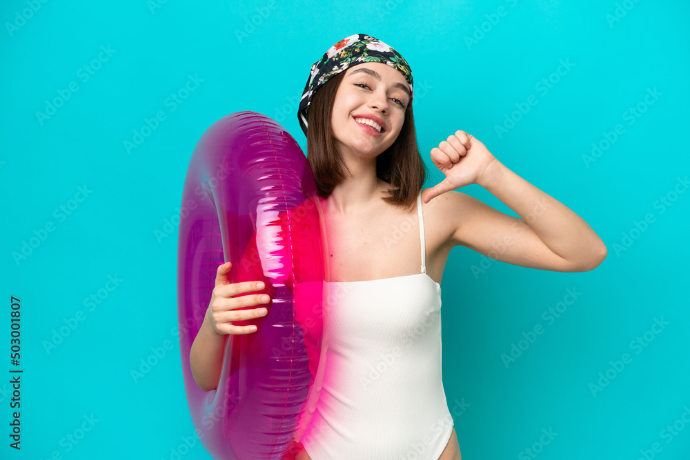 Young Ukrainian woman holding air mattress isolated on blue background proud and self-satisfied Young Ukrainian woman holding air mattress isolated on blue background proud and self-satisfied