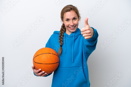 Young caucasian woman playing basketball isolated on white background with thumbs up because something good has happened © luismolinero