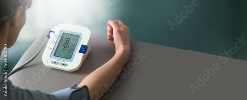 Young woman check blood pressure monitor and heart rate monitor with digital pressure gauge. Health care and Medical concept