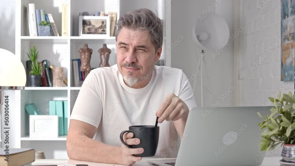 Portrait of 50s man checking news on phone drinking morning coffee at home. Confident happy businessman smiling, reading social media newsfeed, working, Portrait of 50s man checking news on phone drinking morning coffee at home. Confident happy businessman smiling, reading social media newsfeed, working,