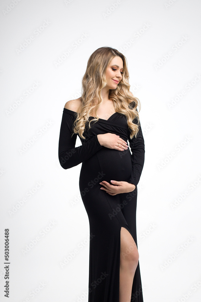 Happy pregnancy woman in black dress on a grey background. Beautiful pregnancy. Vertical photo. Space for text. Happy pregnancy woman in black dress on a grey background. Beautiful pregnancy. Vertical photo. Space for text.