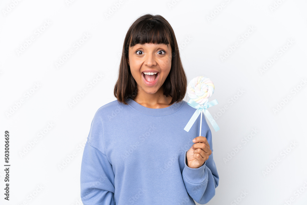 Young mixed race woman holding a lollipop isolated on white background with surprise facial expression Young mixed race woman holding a lollipop isolated on white background with surprise facial expression