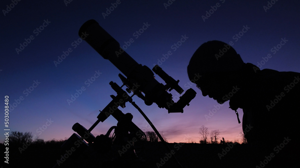 Silhouette of a man, telescope and countryside under evening skies. Silhouette of a man, telescope and countryside under evening skies.