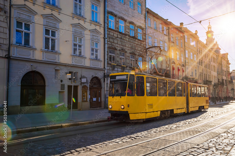 Old tram, traditional houses and narrow street in Old town of Lviv, Ukraine. Sunny weather in Lviv