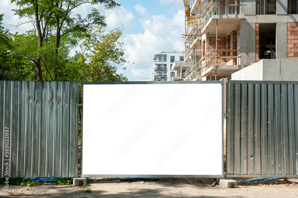 Obraz premium Blank white banner for advertisement mounted on the hoardin of construction site