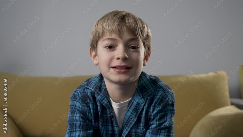 Boy having a video call at home. Child smiling and talking on living room background. View from web camera. Communication via internet with relatives, friends distantly, studying with teacher online. Boy having a video call at home. Child smiling and talking on living room background. View from web camera. Communication via internet with relatives, friends distantly, studying with teacher online.