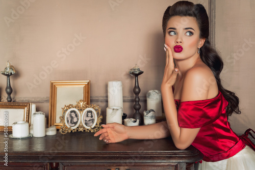 Pretty coquettish pin-up girl in retro interior photo