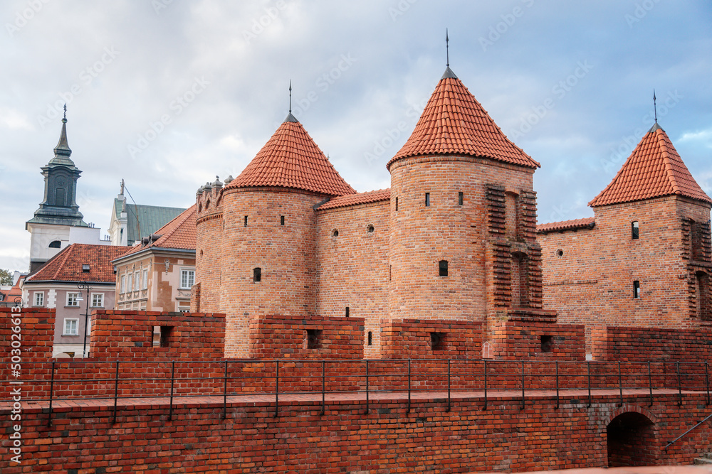 Warsaw, Poland, 13 October 2021: Barbican complex network of historic fortifications between Old and New Town, red brick fort wall with towers, major tourist attraction at sunny autumn day, city gate Warsaw, Poland, 13 October 2021: Barbican complex network of historic fortifications between Old and New Town, red brick fort wall with towers, major tourist attraction at sunny autumn day, city gate