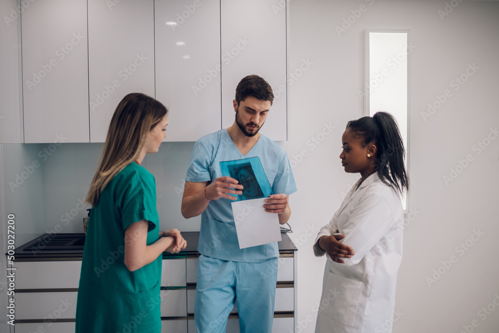 Fototapeta premium Group of doctors looking at x-ray image from jaw