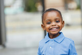 A cute one year old toddler almost preschool age African-American boy with big eyes smiling and looking away with copy space
