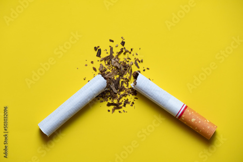 Foto broken cigarette and the tobacco leaves inside on yellow back ground no smoking day concept