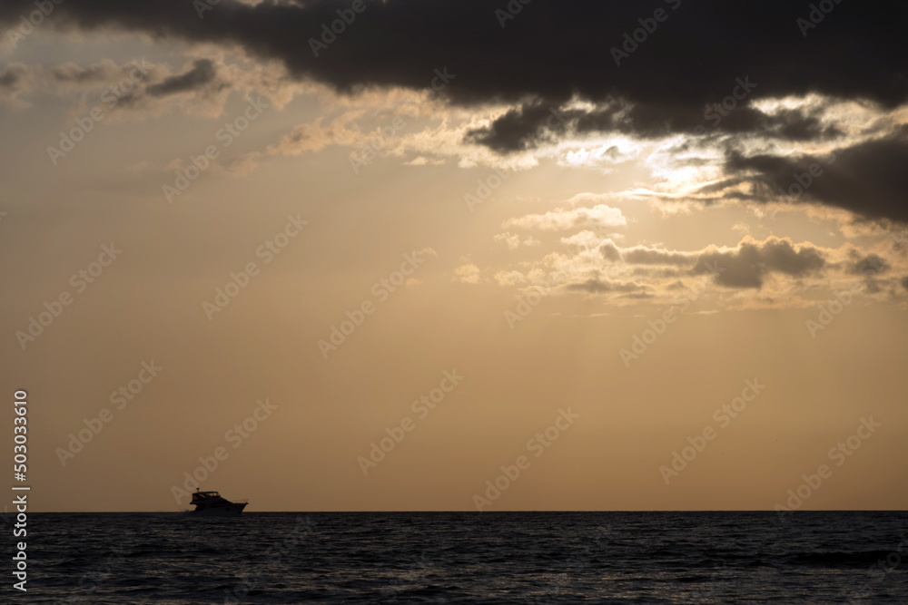 Boat under sunset  clouds near Caspersen Beach