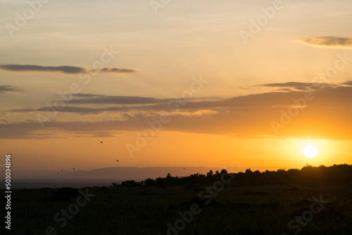 Fleet of Hot Air Balloons Floats Over the Maasai Mara, Kenya at Sunset 