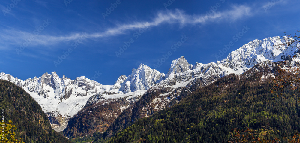 The snow covered Swiss Alp mountain range Sciora viewed from the village Soglio in the Bergell Valley, canton of the Grisons, Switzerland.
