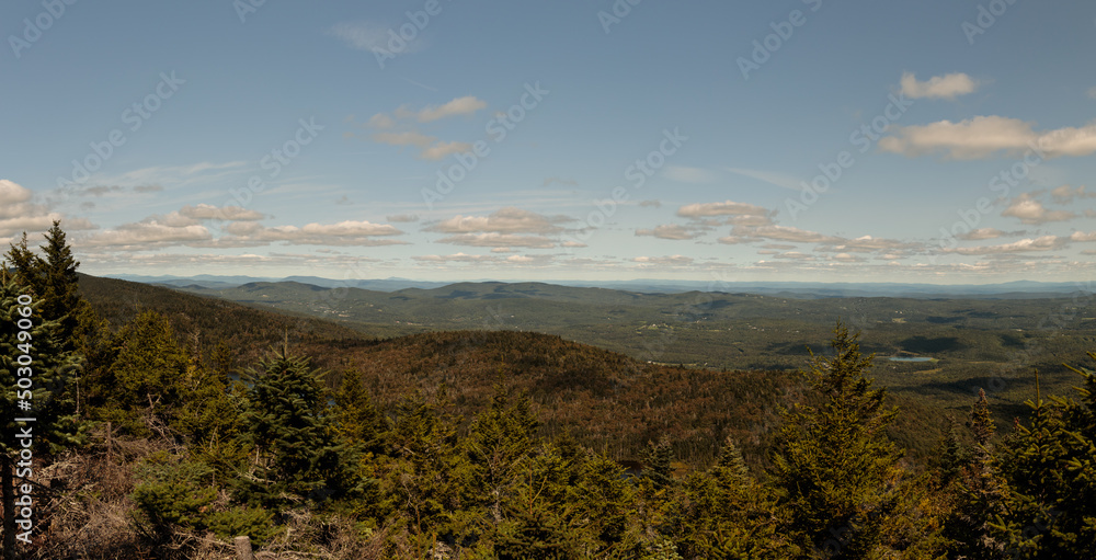 a panoramic view from the top of mount haystack in vermont showing forests, hills and mountains