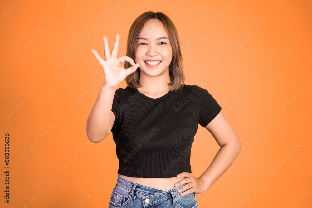 Young woman smiling with okay hand gesture on isolated background Young woman smiling with okay hand gesture on isolated background