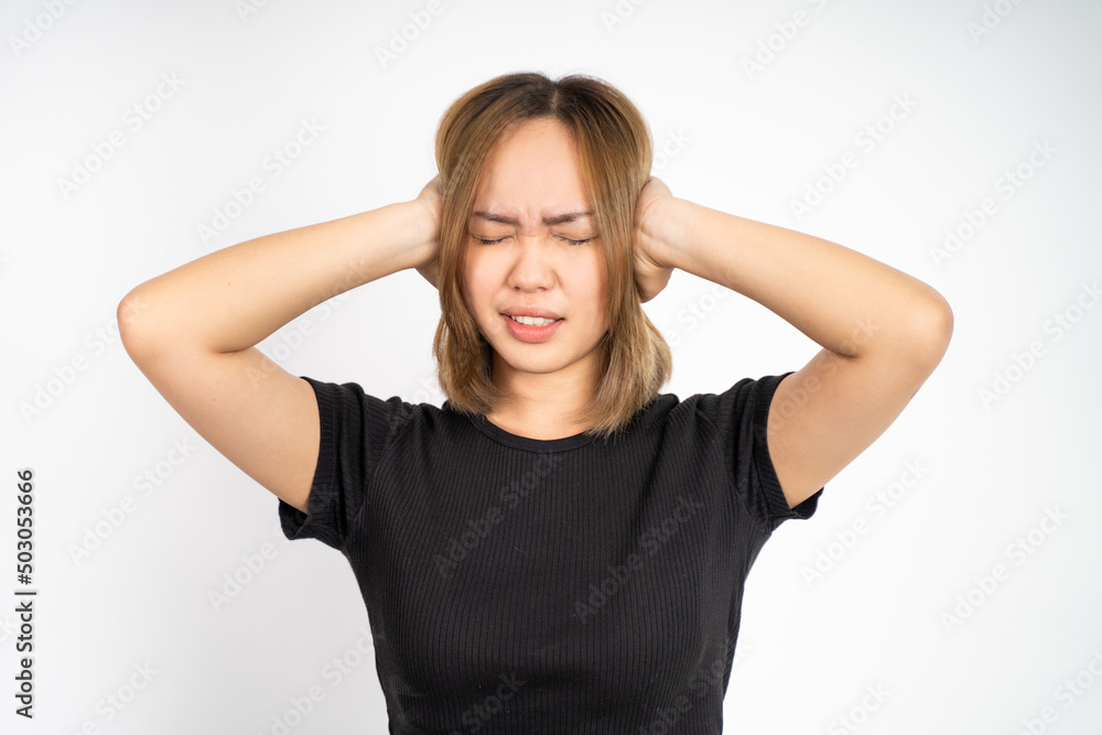 asian woman with annoyed expression covering ears with both hands on isolated background asian woman with annoyed expression covering ears with both hands on isolated background