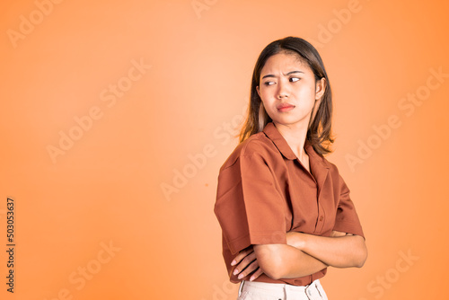 serious expression portrait of young asian woman over isolated background feeling uncertain photo