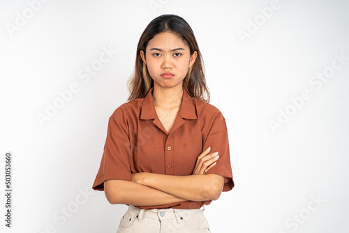 young woman stand cross hand with unhappy sad face on isolated background © Odua Images