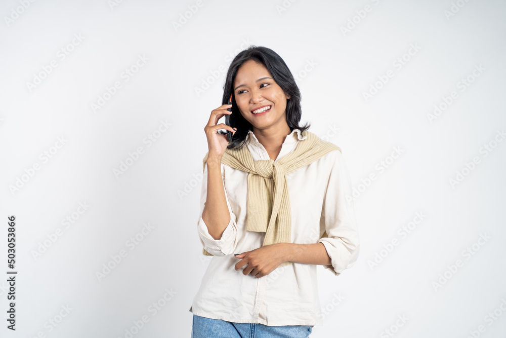 Young asian woman making a call using a cell phone on isolated background Young asian woman making a call using a cell phone on isolated background