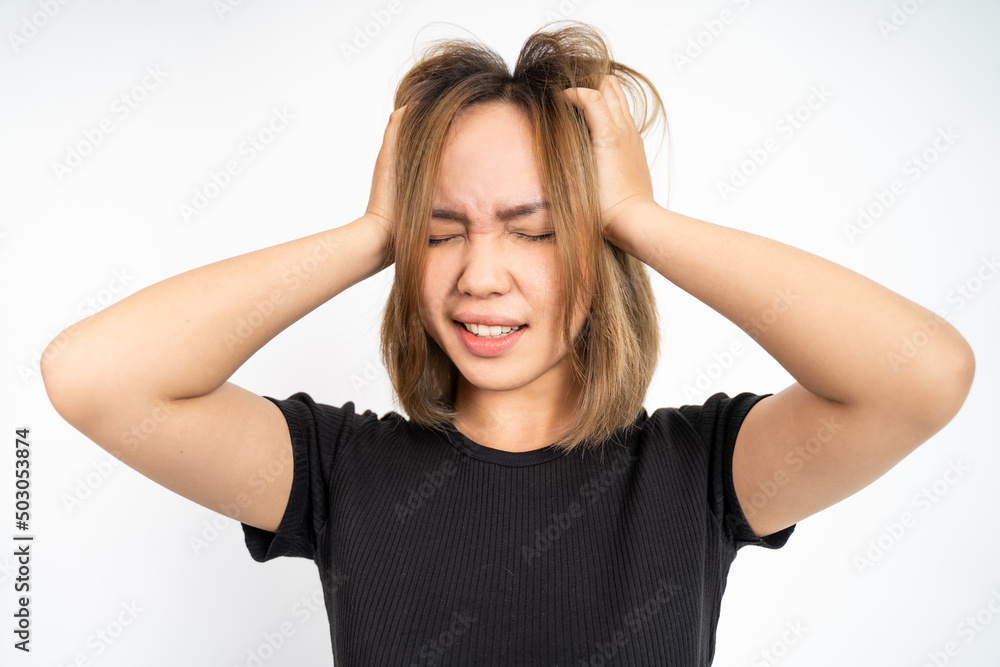 frustrated Asian young woman holding head with headache on isolated orange background frustrated Asian young woman holding head with headache on isolated orange background