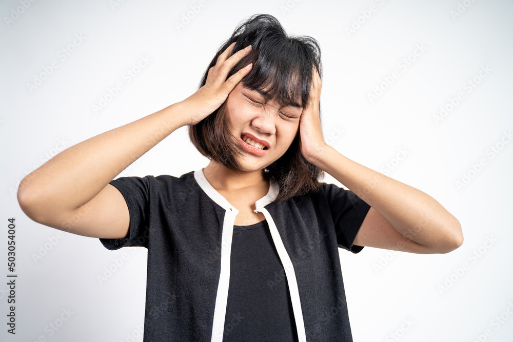 frustrated Asian young woman holding head with headache on isolated orange background frustrated Asian young woman holding head with headache on isolated orange background