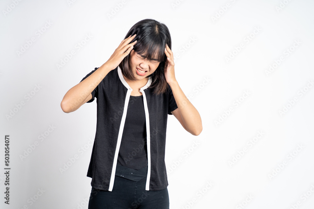 frustrated Asian young woman holding head with headache on isolated orange background frustrated Asian young woman holding head with headache on isolated orange background
