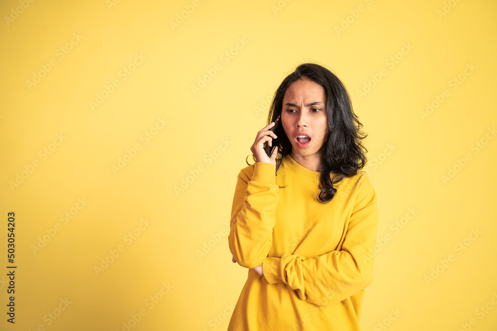 shocked asian woman making a call using a cell phone on isolated background shocked asian woman making a call using a cell phone on isolated background
