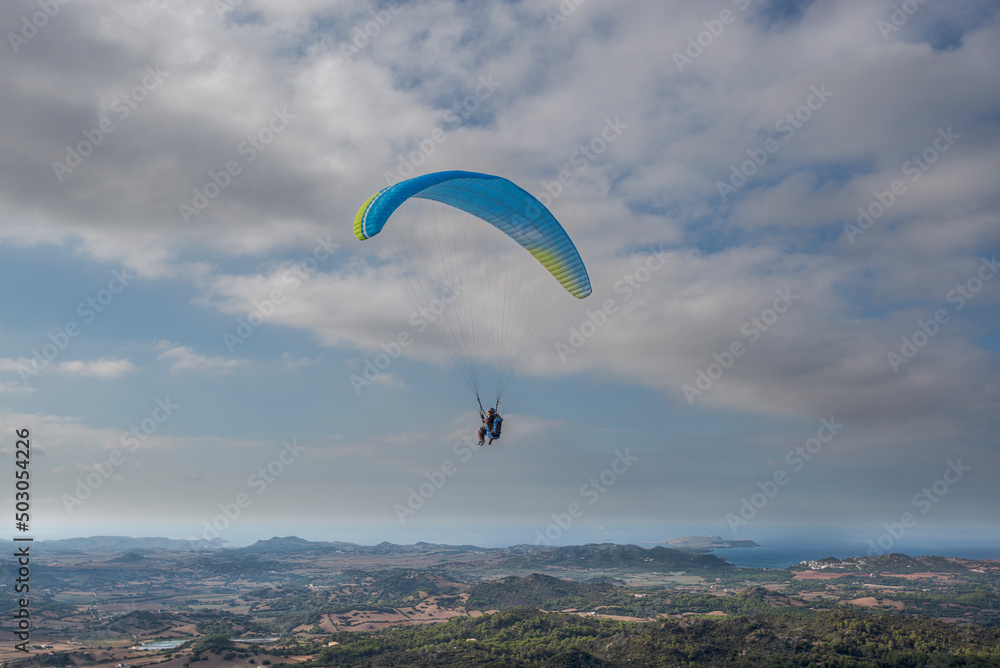 First flight with a tandem paragliding instructor. Photo taken from the El Toro lookout point, municipality of Es Mercadal, Menorca, Spain First flight with a tandem paragliding instructor. Photo taken from the El Toro lookout point, municipality of Es Mercadal, Menorca, Spain