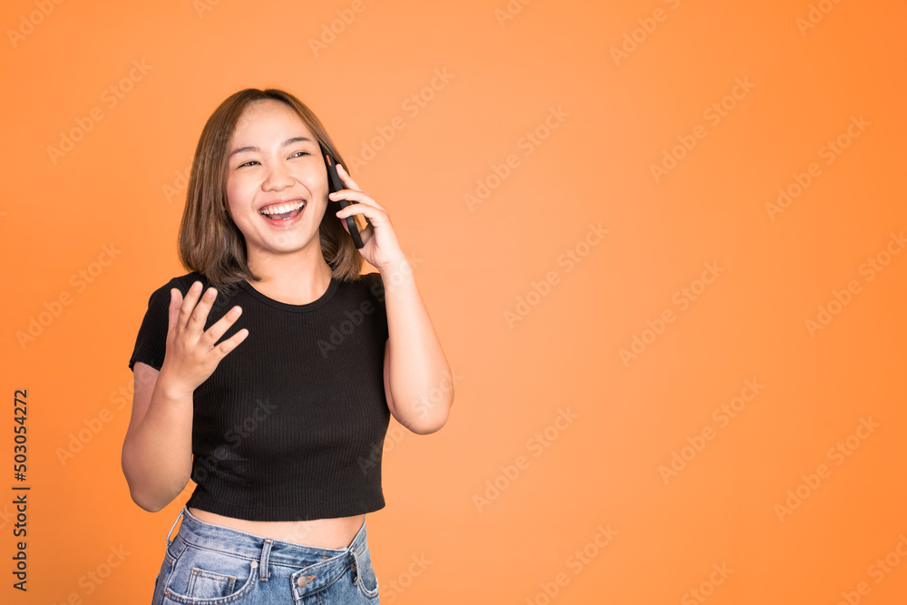 Young asian woman making a call using a cell phone on isolated background Young asian woman making a call using a cell phone on isolated background