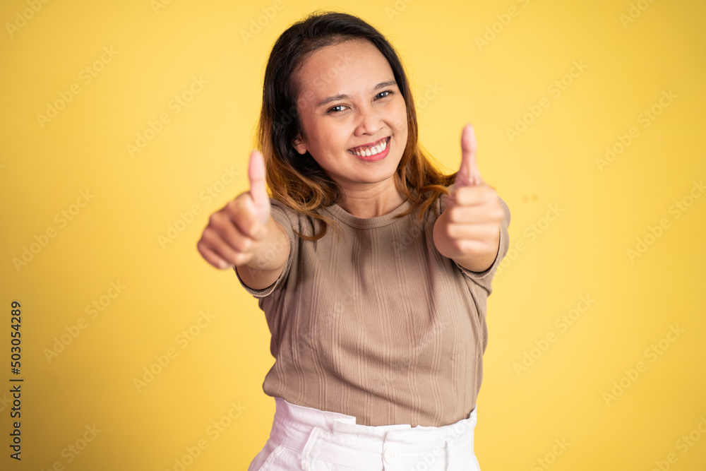 attractive smiling young woman stand with thumbs up on isolated background attractive smiling young woman stand with thumbs up on isolated background