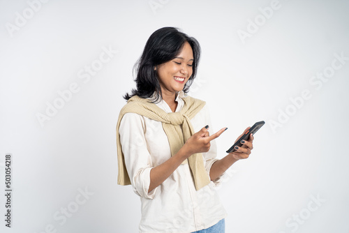 excited asian woman laugh with finger pointing on her mobile phone isolated background