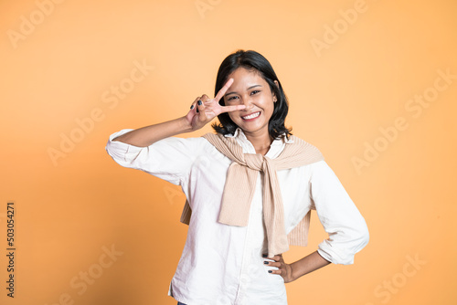 Young asian woman with peaceful hand gesture on isolated background