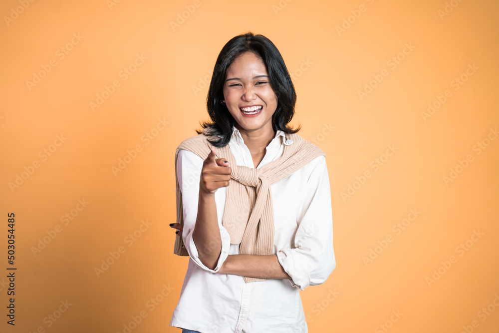 beautiful woman with finger pointing at frong and laughing at something isolated background beautiful woman with finger pointing at frong and laughing at something isolated background