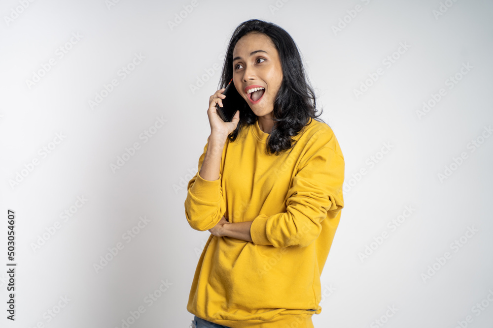 suprised asian woman making a call using a cell phone on isolated background suprised asian woman making a call using a cell phone on isolated background
