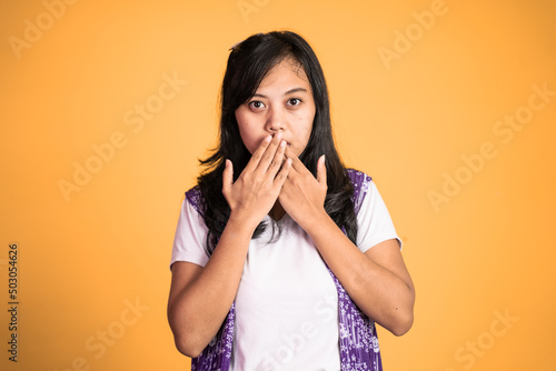 portrait of a asian woman covering her mouth with hands. concept of stop talking