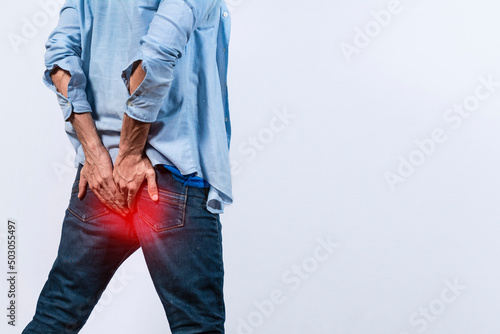 Tapety artystyczne Man with digestive problem touching his buttock, man with hemorrhoid problem on isolated background, Man with diarrhea problem