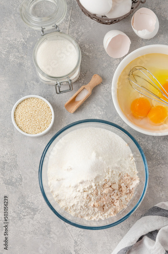 Ingredients for making sweet bread, brioche or challah bread. Yeast, flour, eggs, milk on a gray concrete background. Top view. photo